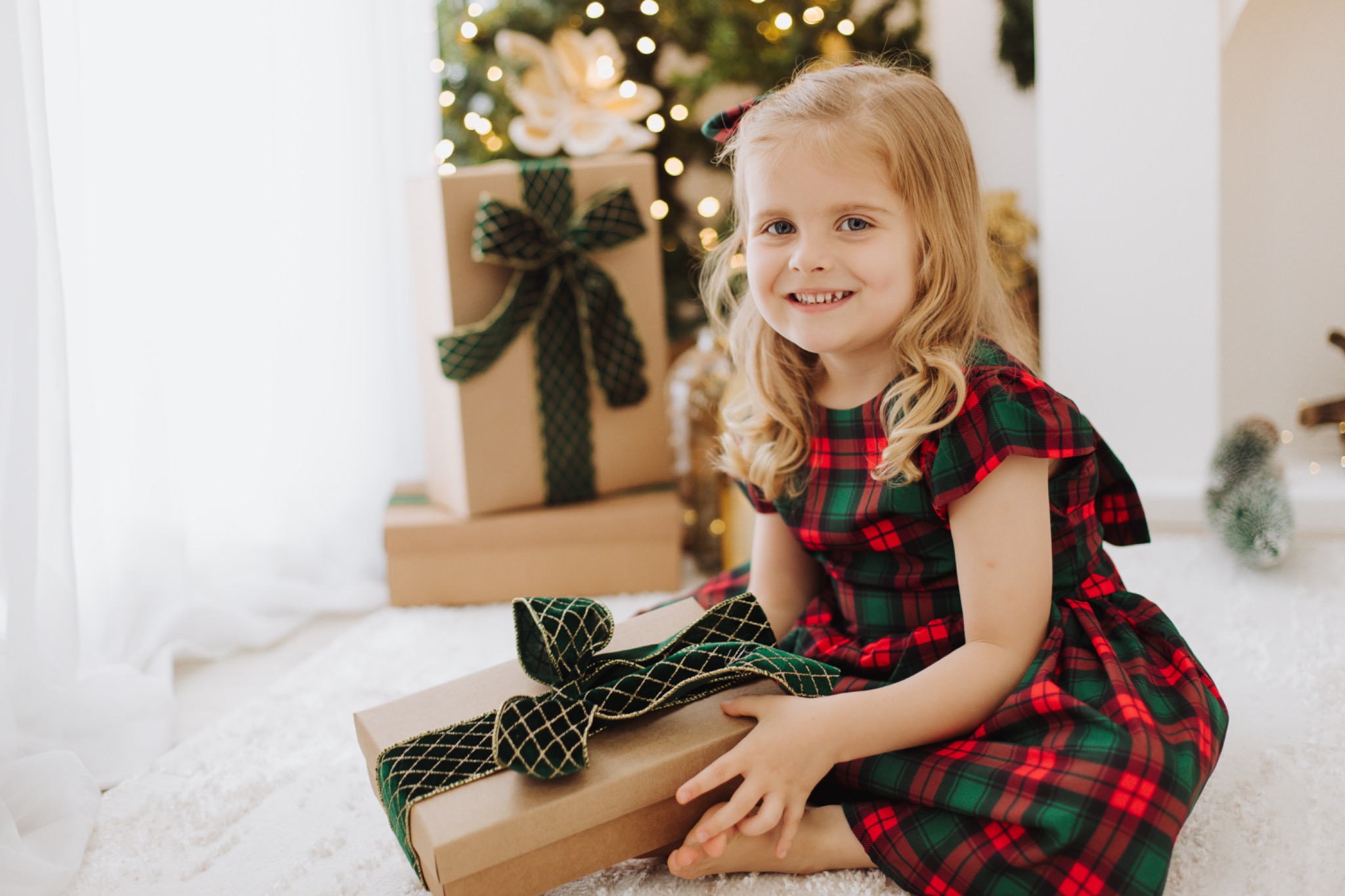Criança sentada com um presente de Natal